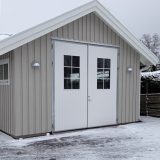 Liten hvit slagport på en liten bygning